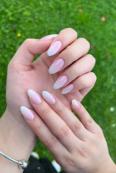 Pink almond nails on green grass